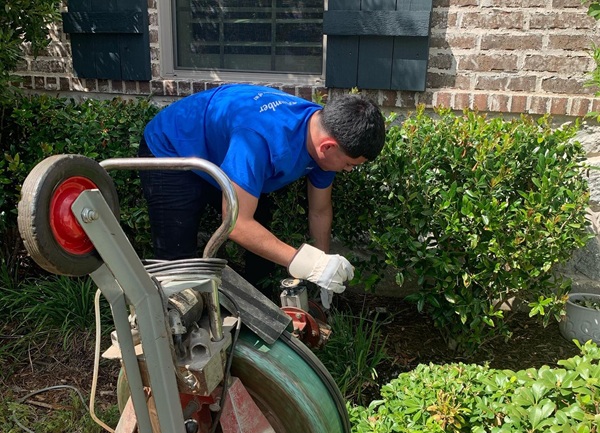 Plumber using equipment to clear drain